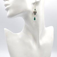 with tiny green crystal beads with dangly teardrop charms at the bottom